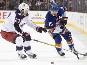 Le défenseur des Blue Jackets de Columbus Ryan Murray (27 ans) patine contre l'ailier droit des Islanders de New York Cal Clutterbuck (15 ans) lors d'un match de la LNH, le samedi 30 novembre 2019 à New York.