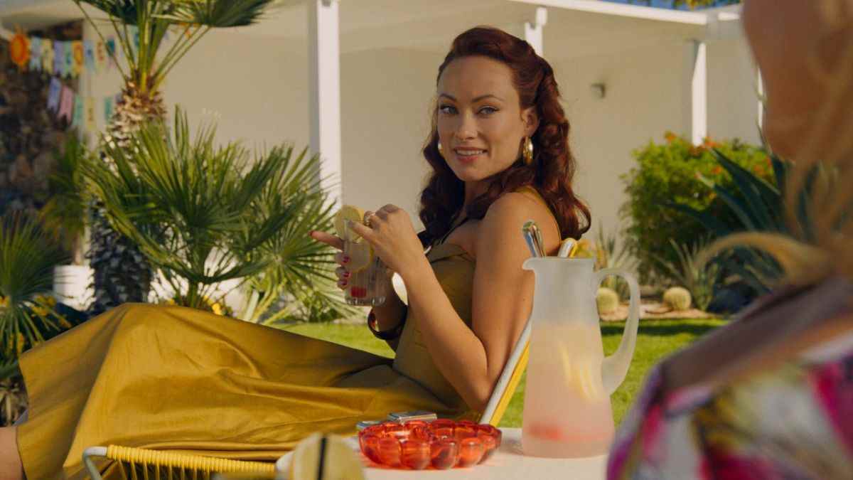 Olivia Wilde in a yellow dress holding a drink in Don