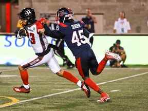 Le receveur large des Redblacks d'Ottawa Jaelon Acklin (23) échappe à la couverture du demi défensif des Alouettes de Montréal Kenneth Durden (45) avec le ballon au cours du deuxième quart au stade Percival Molson Memorial.