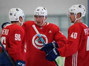 Le New Vancouver Canuck Ilya Mikheyev (au centre) s'entretient avec son nouveau coéquipier russe Andrey Kuzmenko tandis qu'Elias Pettersson (à droite) attend de passer un mot lors de la première journée du camp d'entraînement des Canucks de Vancouver à Whistler le 22 septembre 2022.