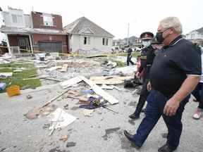 Un jour après qu'une tornade a ravagé un quartier de Barrie et endommagé au moins 150 maisons, le premier ministre de l'Ontario, Doug Ford, examine les dégâts avec le chef de la police de Barrie, Kimberley Greenwood, tout en prenant le temps de parler aux résidents et aux premiers intervenants le vendredi 16 juillet 2021.