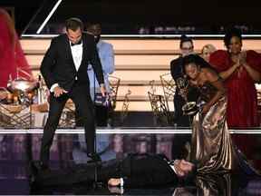 Quinta Brunson (R), flanquée de l'acteur Will Arnett (L), regarde Jimmy Kimmel allongé sur scène après avoir accepté le prix de l'écriture exceptionnelle pour une série comique pour 