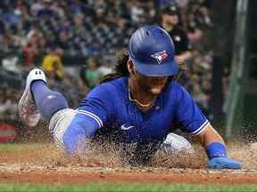 L'arrêt-court des Blue Jays de Toronto Bo Bichette (11) glisse sur le marbre pour marquer un point contre les Pirates de Pittsburgh lors de la quatrième manche au PNC Park.