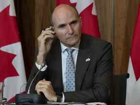 Le ministre de la Santé, Jean-Yves Duclos, écoute un appareil de traduction alors qu'on lui pose une question lors d'une conférence de presse, le lundi 26 septembre 2022 à Ottawa.