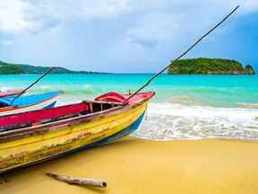 Vieux bateaux de pêche en bois colorés amarrés par l'eau sur une belle côte de plage.  Paysage de bord de mer de sable blanc sur l'île tropicale des Caraïbes