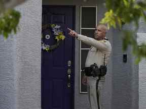 Un policier se tient devant la porte d'entrée de la maison de l'administrateur public du comté de Clark, Robert Telles, le mercredi 7 septembre 2022, à Las Vegas.