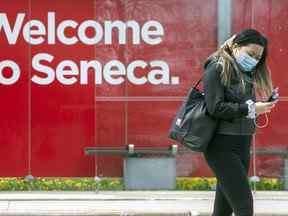 Un piéton portant un masque marche sur le campus du Seneca College à Toronto, le 5 mai 2021. Actuellement, le collège exige que tous les étudiants qui accèdent au campus soient entièrement vaccinés contre la COVID-19.