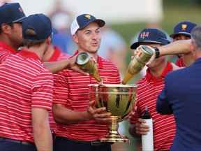 (LR) Jordan Spieth de l'équipe des États-Unis détient la coupe des présidents pour ses coéquipiers lors de la cérémonie de clôture après avoir battu l'équipe internationale lors des matchs en simple du dimanche lors de la quatrième journée de la coupe des présidents 2022 au Quail Hollow Country Club le 25 septembre 2022 à Charlotte, Caroline du Nord.