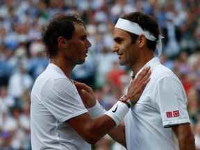 Dans cette photo d'archive prise le 12 juillet 2019, le Suisse Roger Federer (R) s'entretient avec l'Espagnol Rafael Nadal (L) après que Federer a remporté la demi-finale du simple messieurs le jour 11 des championnats de Wimbledon 2019 au All England Lawn Tennis Club à Wimbledon, au sud-ouest de Londres.