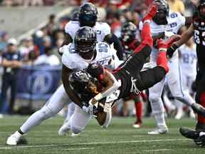 Le porteur de ballon des Redblacks Devonte Williams est renversé alors qu'il court avec le ballon devant Henoc Muamba des Argonauts le 10 septembre. Muamba soigne une blessure oblique mais il espère jouer samedi contre Ottawa.