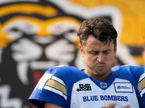 Le quart-arrière des Blue Bombers de Winnipeg Zach Collaros (8) fait une pause pendant un moment de silence pour la reine Elizabeth II avant le match de football de la LCF contre les Tiger Cats de Hamilton à Hamilton, en Ontario.  le samedi 17 septembre 2022.