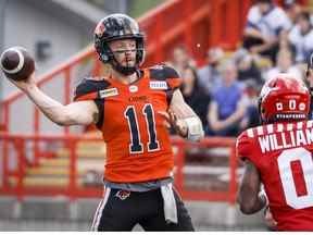 Le quart-arrière des Lions de la Colombie-Britannique Michael O'Connor, à gauche, lance le ballon alors que Darius Williams des Stampeders de Calgary se rapproche lors de la première mi-temps de l'action de football de pré-saison de la LCF à Calgary, en Alberta, le samedi 28 mai 2022.