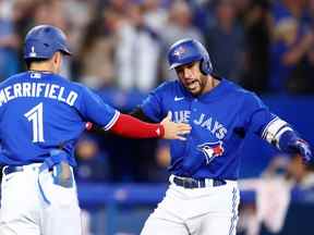 George Springer, à droite des Blue Jays de Toronto, célèbre avec Whit Merrifield après avoir frappé un coup de circuit de deux points en septième manche lors du deuxième match d'un programme double contre les Rays de Tampa Bay au Rogers Centre le 13 septembre 2022 à Toronto.