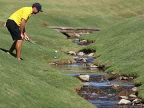 Corey Conners du Canada de l'équipe internationale sort sa balle de l'eau lors d'une ronde d'entraînement à la Coupe des présidents au Quail Hollow Country Club à Charlotte, en Caroline du Nord, hier.