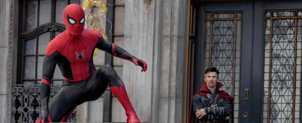 Spider-Man crouches on top of a car while Dr. Strange looks on with his arms crossed