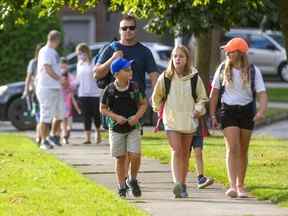 Jason Yeo marche avec ses enfants Tyler, 8 ans, leur amie Katie Vilon, 12 ans (obscurcie Nathan, 5 ans) et Britton Yeo, 10 ans, lors de leur premier jour d'école le 7 septembre 2021. (Mike Hensen/The London Free Press )