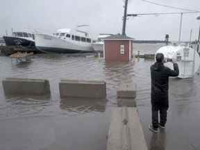 Un résident prend des photos d'inondations à la suite de la tempête post-tropicale Fiona à Shediac, au Nouveau-Brunswick