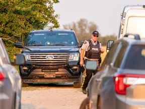 Un policier entre sur une scène de crime à Weldon, en Saskatchewan, le dimanche 4 septembre 2022.