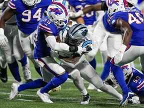 Le porteur de ballon des Panthers de la Caroline John Lovett (37) est attaqué par le demi de coin des Buffalo Bills Cam Lewis (39) au cours de la seconde moitié au stade Bank of America.