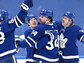 L'attaquant des Maple Leafs de Toronto Mitchell Marner célèbre un but contre les Devils du New Jersey avec les attaquants Auston Matthews et Michael Bunting et le défenseur Timothy Liljegren en troisième période à la Scotiabank Arena.