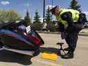 Const.  Trevor Henderson de la section de la circulation du service de police d'Edmonton teste le niveau de bruit d'une moto le 28 mai 2020 à Edmonton.