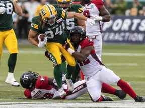 Le Rouge et Noir d'Ottawa Avery Williams (42) s'attaque aux Elks d'Edmonton Ante Liter (34) lors de la première mi-temps de l'action de la LCF à Edmonton, en Alberta, le samedi 27 août 2022.