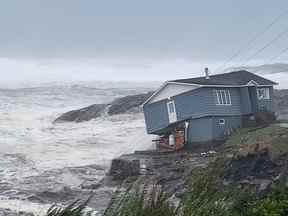 Des vagues déferlent près d'une maison endommagée construite près du rivage alors que l'ouragan Fiona, plus tard déclassé en cyclone post-tropical, passe devant la colonie atlantique de Port aux Basques, Terre-Neuve-et-Labrador, Canada le 24 septembre 2022. Avec l'aimable autorisation de Wreckhouse Press/Handout par Reuters