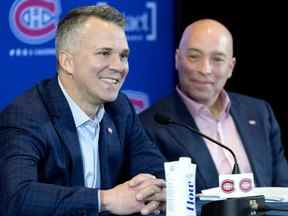 Le directeur général des Canadiens de Montréal, Kent Hughes, à droite, écoute le discours de l'entraîneur-chef par intérim Martin St. Louis lors d'une conférence de presse à Montréal le 10 février 2022.