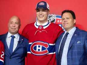 Kent Hughes, à gauche, accueille Juraj Slafkovsky avec Jeff Gorton en tant que première sélection des Canadiens de Montréal lors du repêchage de la LNH à Montréal le 7 juillet 2022.