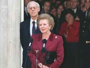 Le Premier ministre britannique Margaret Thatcher entourée de son mari Denis le 28 novembre 1990 devant le 10 Downing Street à Londres.