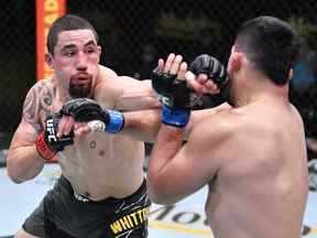 Sur cette photo, (LR) Robert Whittaker d'Australie frappe Kelvin Gastelum dans un combat de poids moyen lors de l'événement UFC Fight Night à l'UFC APEX le 17 avril 2021 à Las Vegas, Nevada.