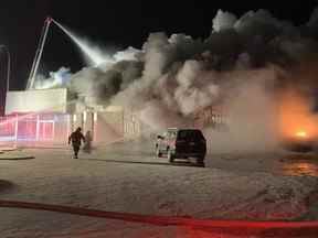 Les équipes de pompiers combattent un incendie le 30 décembre 2019 chez un concessionnaire Honda à Edson.  L'incendie était l'un des cinq incendies criminels présumés survenus dans les villes de l'ouest de l'Alberta fin 2019/début 2020. L'homme accusé des incendies criminels, Thomas Berube, a entamé un procès sur les accusations le 22 août 2022.