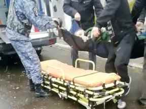 Un homme est mis sur une civière après une fusillade dans un bureau de recrutement militaire à Ust-Ilimsk, région d'Irkoutsk, Russie le 26 septembre 2022 dans cette capture d'écran obtenue à partir d'une vidéo sur les réseaux sociaux.