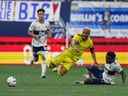 Hany Mukhtar du Nashville FC, avant gauche, est renversé par Javain Brown des Whitecaps de Vancouver lors de la première mi-temps de l'action de football MLS à Vancouver le samedi 27 août 2022.