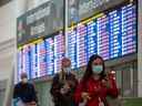 Les voyageurs vérifient leur téléphone aux arrivées internationales à l'aéroport international Pearson de Toronto le 26 septembre 2022.