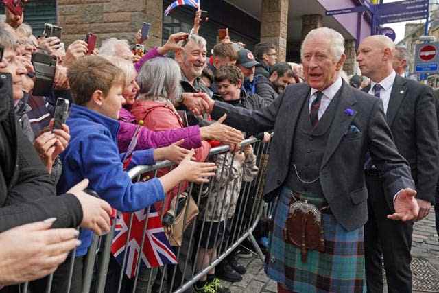 Le roi Charles III accueille les membres du public alors qu'il arrive à une réunion officielle du conseil à la City Chambers à Dunfermline, Fife, pour marquer officiellement l'attribution du statut de ville à l'ancienne ville, avant une visite à l'abbaye de Dunfermline pour marquer son 950e anniversaire 