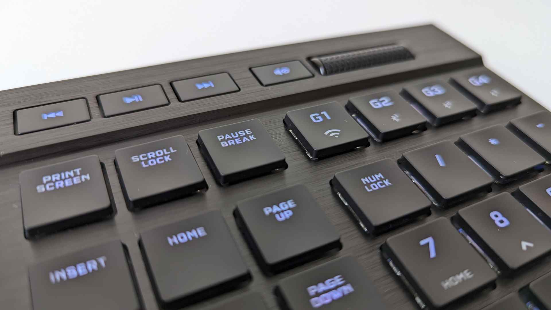 Le coin supérieur droit du Corsair K100 Air, dans lequel on peut voir les touches multimédias dédiées et le rouleau de volume