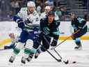 1er octobre 2022 ;  Seattle, Washington, États-Unis ;  Le défenseur des Canucks de Vancouver Oliver Ekman-Larsson (23) patine avec la rondelle contre l'aile gauche de Seattle Kraken Brandon Tanev (13) au cours de la première période au Climate Pledge Arena.  Crédit obligatoire : Joe Nicholson-USA TODAY Sports