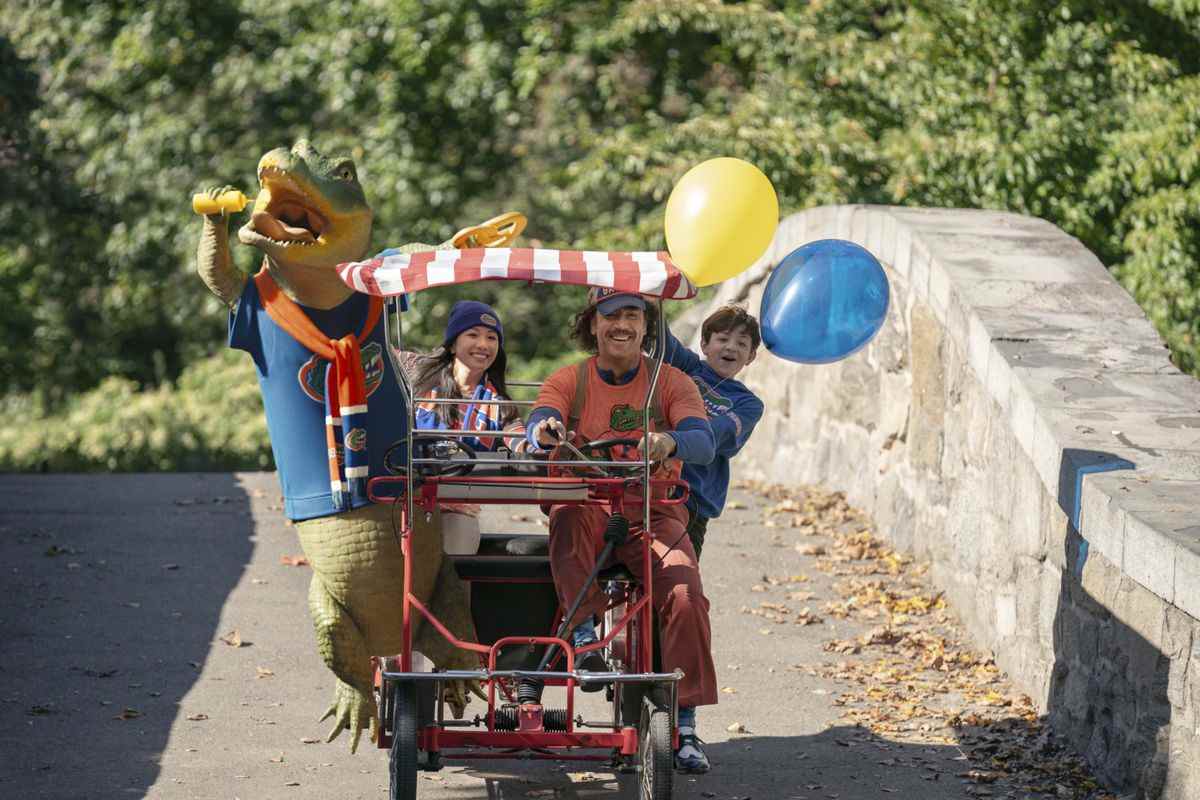 Lyle monte sur Surrey avec Constance Wu, Javier Bardem et un enfant aux cheveux bruns enthousiaste tenant des ballons à travers Central Park  