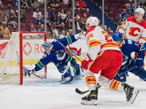 Le défenseur des Flames de Calgary Michael Stone marque le vainqueur des prolongations sur le gardien des Canucks de Vancouver Arturs Silvos lors d'un match pré-saison au Rogers Arena de Vancouver le 25 septembre 2022. Les Flames ont gagné 3-2.