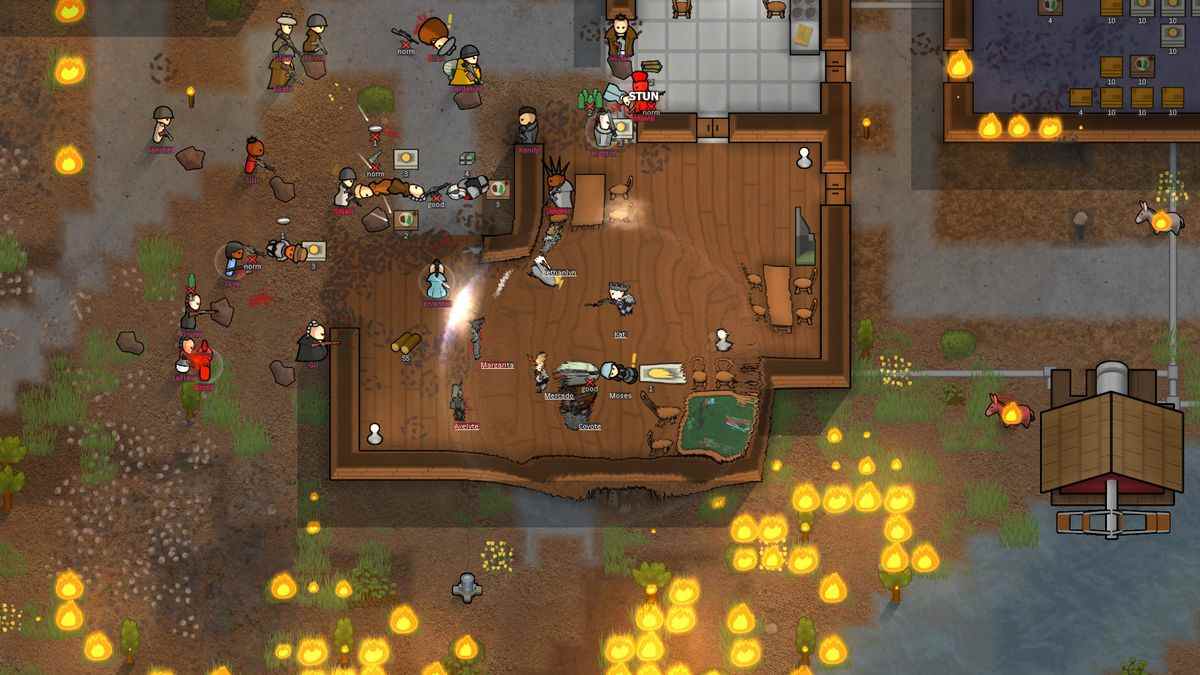 RimWorld - Une impulsion se produit à l'intérieur d'une maison en bois, endommageant les colons à l'intérieur alors qu'un incendie fait rage au sud et que les attaquants s'approchent du nord.