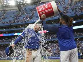 1er octobre 2022 ;  Toronto, Ontario, CAN ;  Le joueur de premier but des Blue Jays de Toronto, Vladimir Guerrero Jr., à droite, jette un seau d'eau glacée sur le receveur Danny Jansen après une victoire contre les Red Sox de Boston au Rogers Centre.