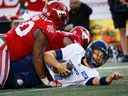 Le quart-arrière des Argonauts de Toronto McLeod Bethel-Thompson est limogé par Isaac Adeyemi-Berglund et Shawn Lemon des Stampeders de Calgary lors d'un match de football de la LCF à Calgary samedi soir.