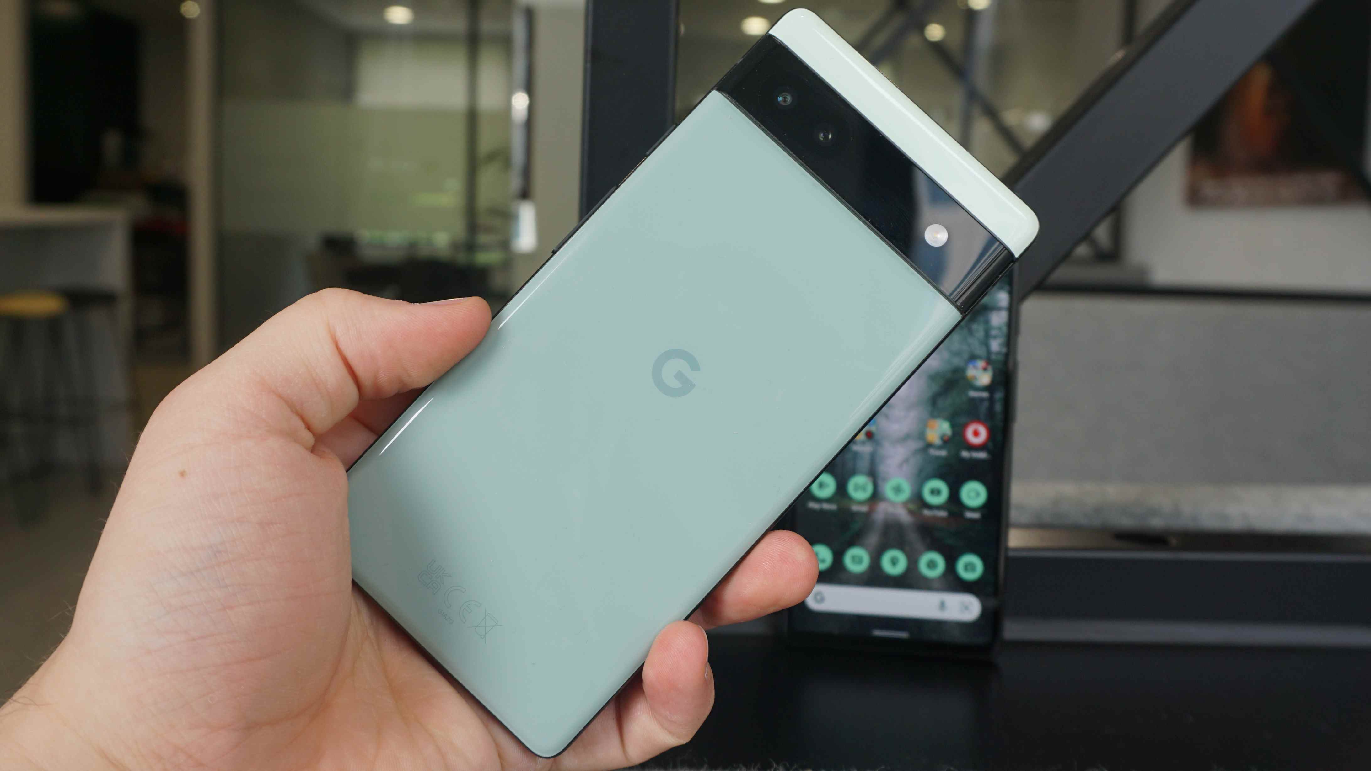 Un Google Pixel 6a dans la main de quelqu'un, de dos