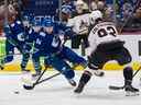 Le défenseur des Coyotes de l'Arizona Vladislav Kolyachonok (92) trébuche sur l'attaquant des Canucks de Vancouver Linus Karlsson (94) en première période au Rogers Arena. 