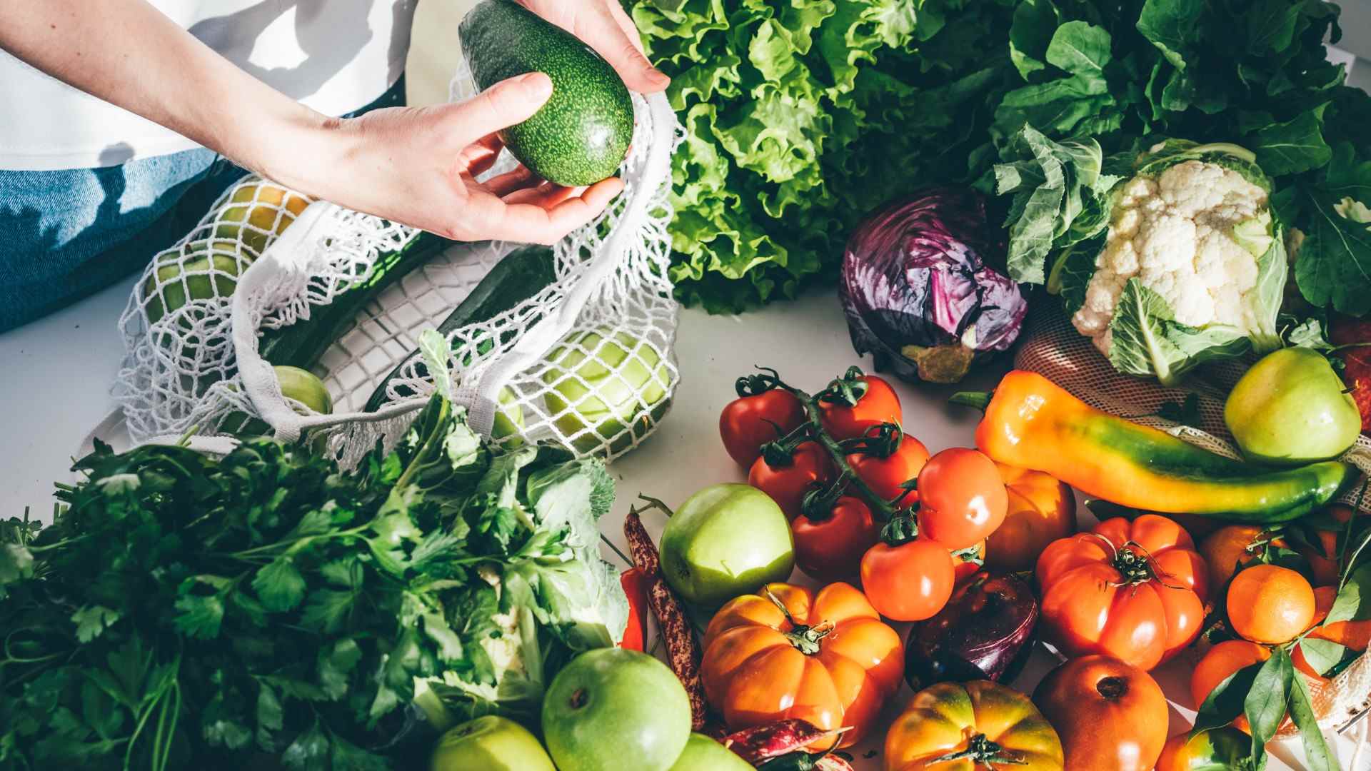 Image de fruits et légumes sains et de quelqu'un prenant un avocat