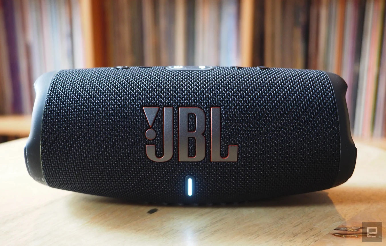 Le JBL Charge 5 photographié pour le guide des haut-parleurs Bluetooth portables 2022 d'Engadget devant une étagère pleine de disques.