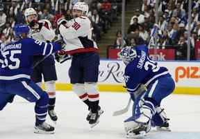 Le gardien de but des Maple Leafs Ilya Samsonov effectue un arrêt alors que Marcus Johansson (au centre) des Capitals et Mark Giordano des Maple Leafs s'affrontent en première période.  FRANK GUNN/LA PRESSE CANADIENNE