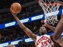 Christian Koloko des Raptors de Toronto prend le ballon dans le panier lors d'un match de pré-saison de la NBA contre les Utah Jazz à Rogers Place .  Edmonton le 2 octobre 2022.