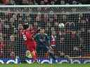 Le milieu de terrain japonais de Liverpool Takumi Minamino (L) frappe le ballon au-dessus de la barre avec le but à sa merci lors du match de football aller de la demi-finale de la Coupe de la Ligue anglaise entre Liverpool et Arsenal à Anfield à Liverpool, dans le nord-ouest de l'Angleterre, le 13 janvier 2022 .  